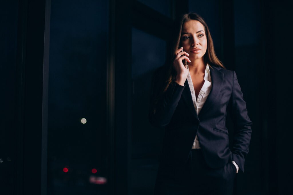 business woman talking on the phone and staying late at night at the office