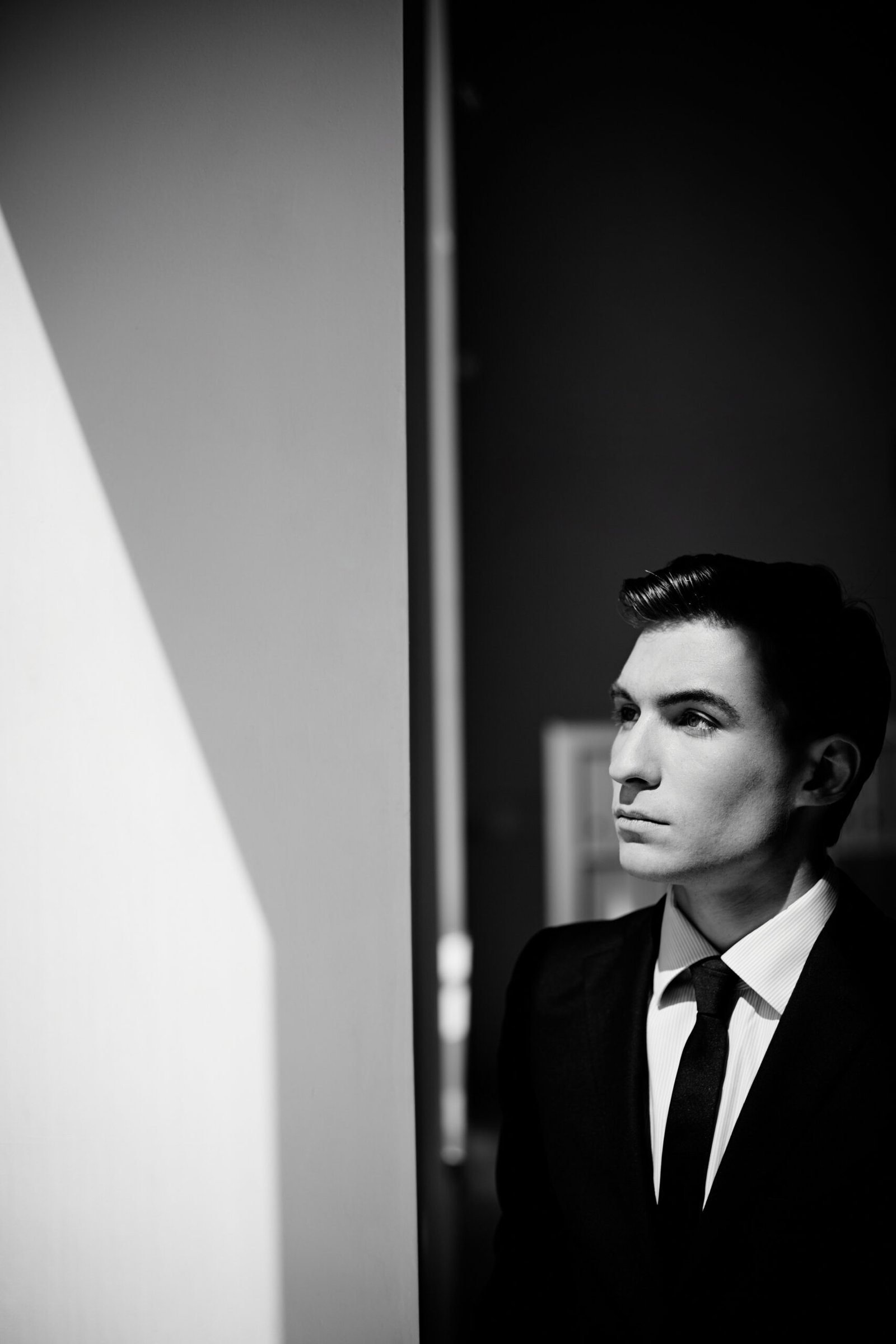 gentleman looking out of window black and white